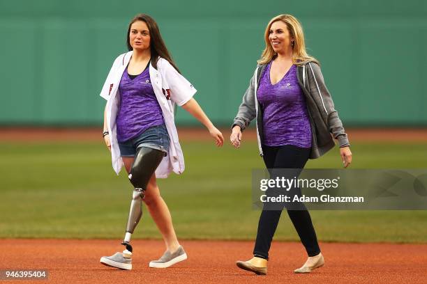 Boston Marathon bombing survivors Heather Abbott and Noelle Lambert are introduced during a ceremony before a game between the Boston Red Sox and the...