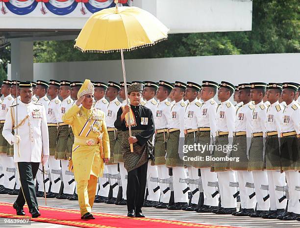 Sultan Mizan Zainal Abidin, Malaysia's new king, salutes as he walks past a line of guards at a welcoming ceremony in Parliament, Kuala Lumpur,...