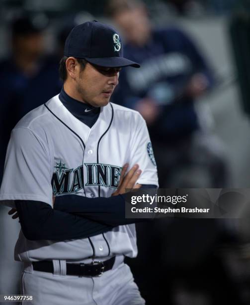 Hisashi Iwakuma of the Seattle Mariners stands in the dugout before a game against the Oakland Athletics at Safeco Field on April 14, 2018 in...