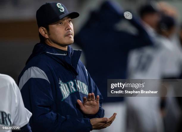 Hisashi Iwakuma of the Seattle Mariners applauds while standing in the dugout before a game against the Oakland Athletics at Safeco Field on April...