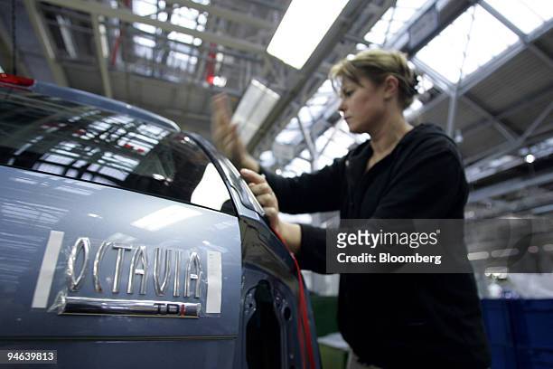 An auto worker sets window glass on an assembly line at the factory headquarters of Skoda Auto S.A.. In Mlada Boleslav, Czech Republic, on Tuesday,...