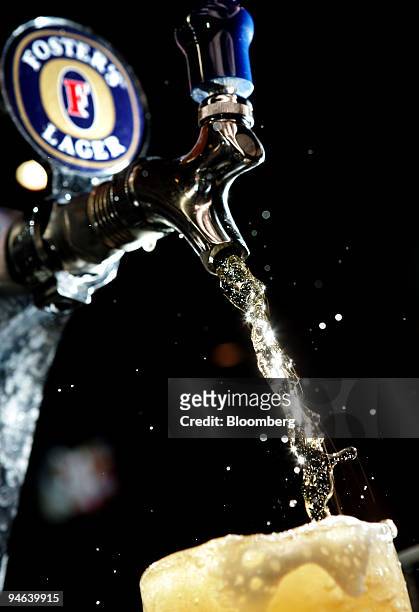Member of the bar staff pours a glass of Foster's Lager from the tap at a pub in Sydney, Australia, on Monday, Aug. 27, 2007. Foster's Group Ltd. ,...