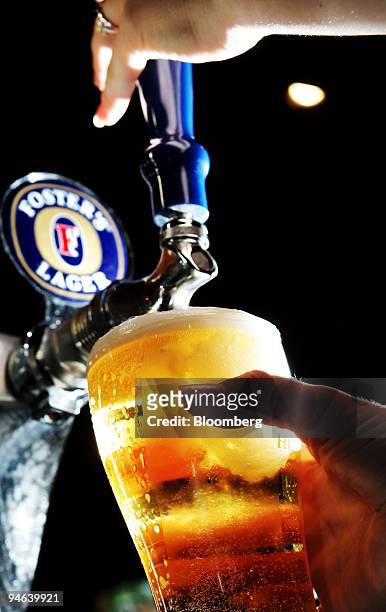 Member of the bar staff pours a glass of Foster's Lager from the tap at a pub in Sydney, Australia, on Monday, Aug. 27, 2007. Foster's Group Ltd. ,...