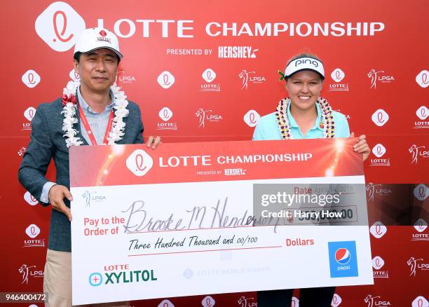 Brooke Henderson of Canada is presented the winner's check by Kap Lee, CEO of Dahong Communications, after her four shot victory during the fourth...