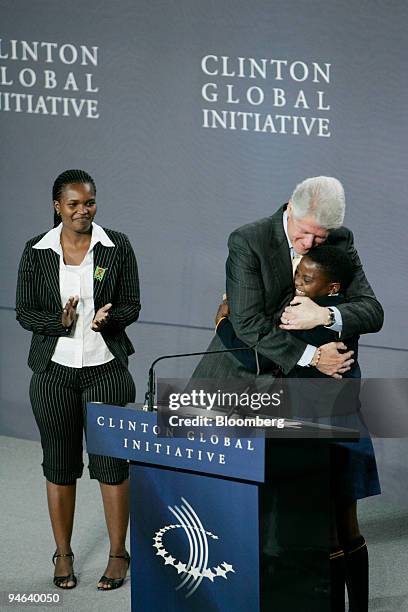 Former President Bill Clinton embraces 17 year-old South African Zethu Ngceza during a mid-year meeting of the Clinton Global Initiative at the Time...