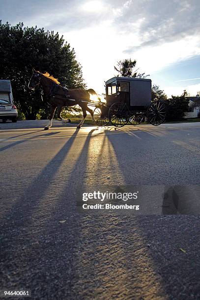 Traditional Amish horse and buggy drives a team of horses pulling a cart along a highway towards Nickel Mines, Pennsylvania Thursday, October 5,...