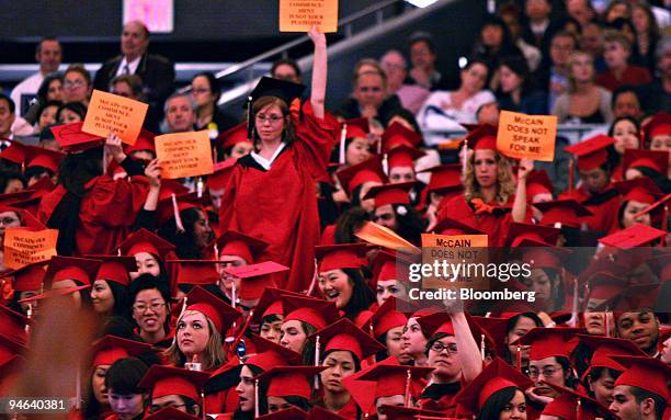 Students hold signs during an address by U.S. Senator John McCain at The New School commencement ceremony in New York's Madison Square Garden,...