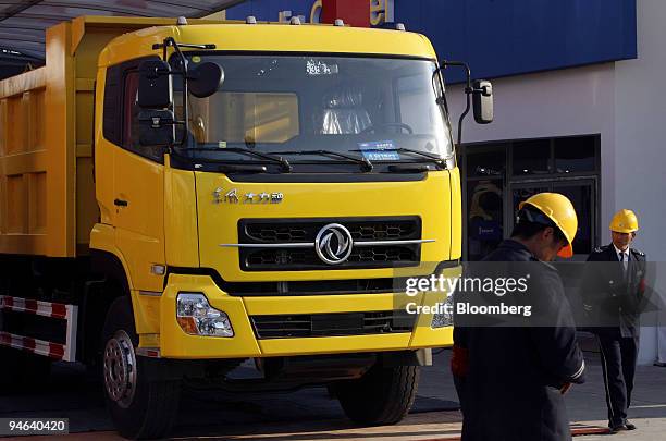 Security guards walk besides a Dongfeng Motor Corp. Truck at The Shanghai International Auto Show in Shanghai, China, on Thursday, April 19, 2007....