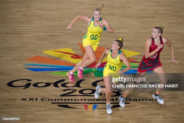 Australia's Joanna Weston, Gabi Simpson and England's Serena Guthrie compete for the bale during their women's field netball gold medal match against...