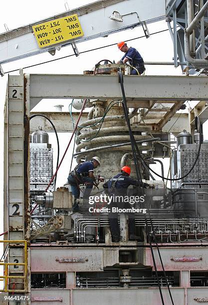 Laborers work atop the blowout preventer aboard the Discoverer Deep Seas, a Transocean deepwater drill ship, Monday, December 11 in the Gulf of...