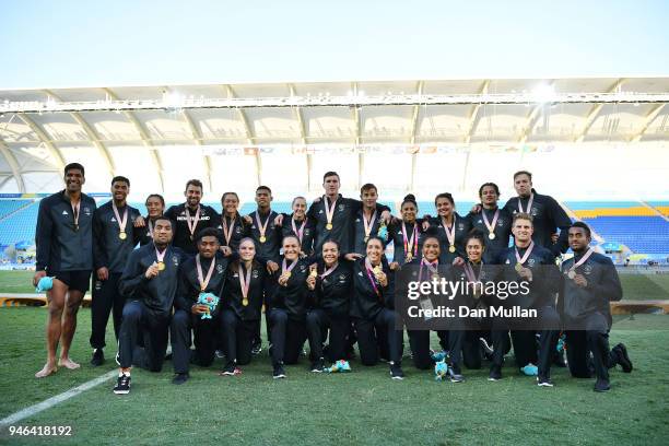 New Zealand men and women's team pose with their gold medals following their wins in the Rugby Sevens Gold Medal matches on day 11 of the Gold Coast...