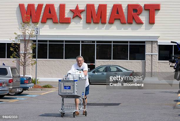 Richard Dawson pushes a cart holding items he purchased at a Wal-Mart store in Framingham, Massachusetts Friday, July 28, 2006. In response to higher...