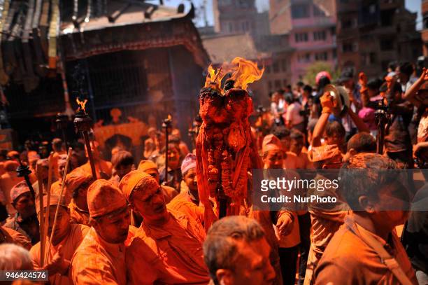 Devotees carrying oil torch frame during the celebration of &quot;Sindoor Jatra&quot; vermillion powder festival or Nepalese New Year day celebration...