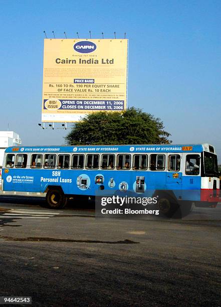 Bus passes before a sign for Cairn India Ltd.'s initial public offering in Hyderabad, India, on Sunday, December 10, 2006. Cairn India Ltd., which is...