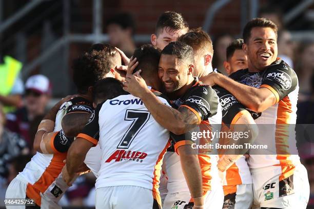 Malakai Watene-Zelezniak of the Tigers celebrates with team mates after scoring a try during the round six NRL match between the Manly Sea Eagles and...