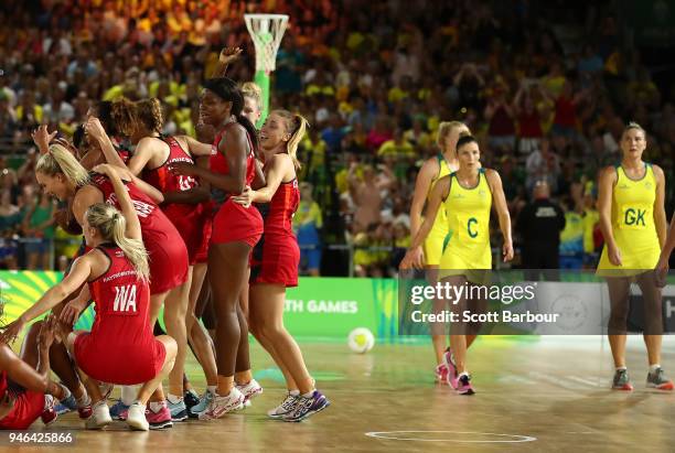 England celebrate at full time and winning as Australia look dejected as they leave the court during the Netball Gold Medal Match between England and...