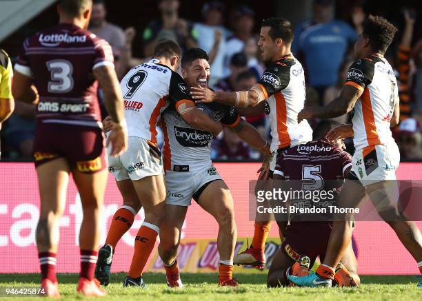Malakai Watene-Zelezniak of the Tigers celebrates with team mates after scoring a try during the round six NRL match between the Manly Sea Eagles and...