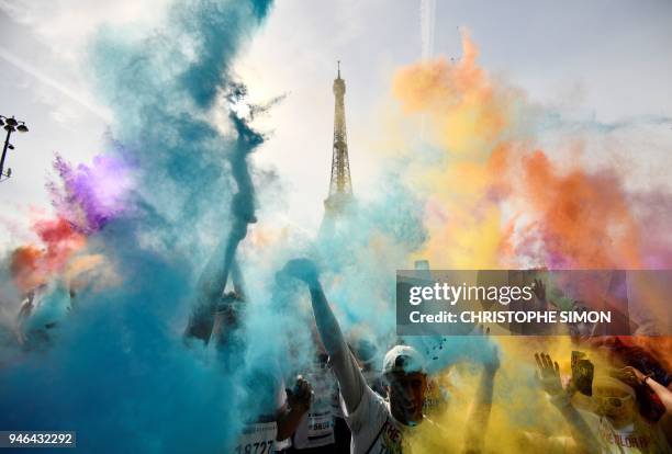 People celebrate at the end of the Color Run 2018 race in front of the Eiffel Tower in Paris, on April 15, 2018. - The Color Run is a five kilometres...