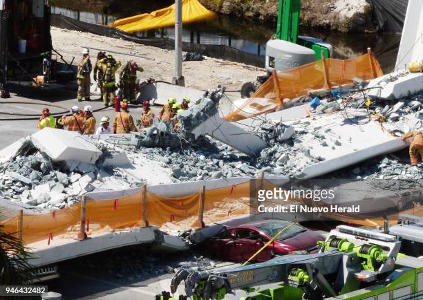 Rescuers search through the rubble of the FIU pedestrian bridge collapse on Thursday, March 15 at SW 109th Avenue and 8th Street in Miami.