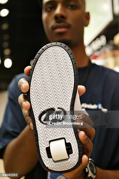 Heelys sneaker is held for a photograph by The Finish Line employee Byron Wesson in Dallas, Texas, Friday, December 8, 2006.