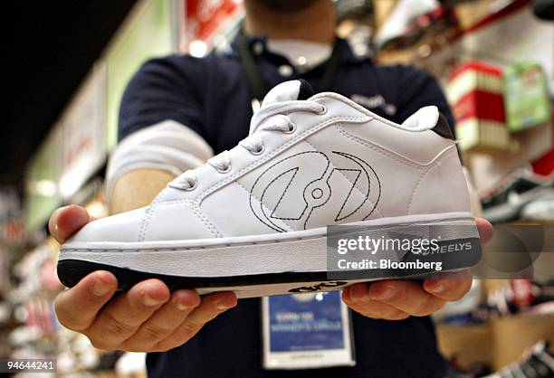 Heelys sneaker is held for a photograph by The Finish Line employee Jordan Murray in Dallas, Texas, Thursday, December 7, 2006.