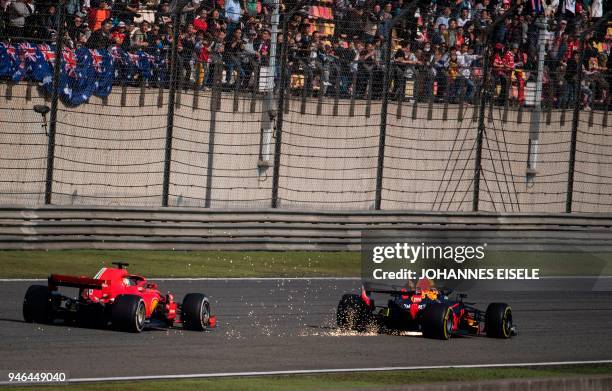 Sparks fly as Red Bull's Australian driver Daniel Ricciardo overtakes Ferrari's German driver Sebastian Vettel during the Formula One Chinese Grand...