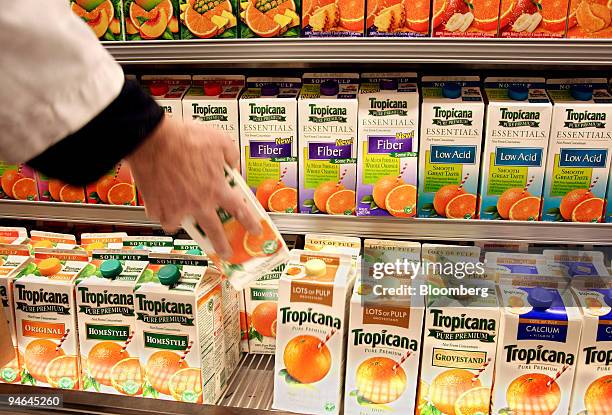 Grocer stocks orange juice at a grocery store in New York, Thursday, December 07, 2006. Orange-juice prices rose to a record of $2.094 a pound on the...
