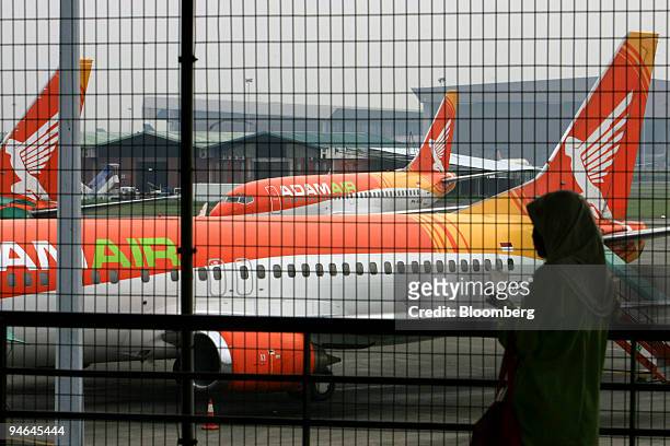 Adam Air passenger planes are seen as a woman waits in the arrivals of Soekarno-Hatta International Airport, in Cengkareng, near Jakarta, Indonesia,...