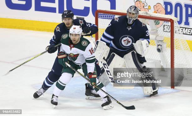 Mark Scheifele of the Winnipeg Jets battles with Jason Zucker of the Minnesota Wild in front of Jets goalie Connor Hellebuyck in Game Two of the...