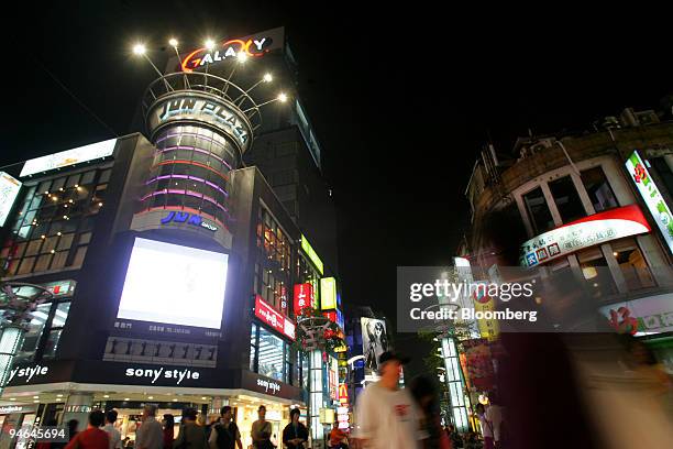 Pedestrians walk past a shopping area in Taipei, Taiwan, on Monday, April 16, 2007. China's missiles may not be the biggest danger to Taiwan. An...