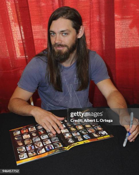 Actor Tom Payne of 'The Walking Dead' signs autographs on Day 1 of Monsterpalooza held at Pasadena Convention Center on April 14, 2018 in Pasadena,...