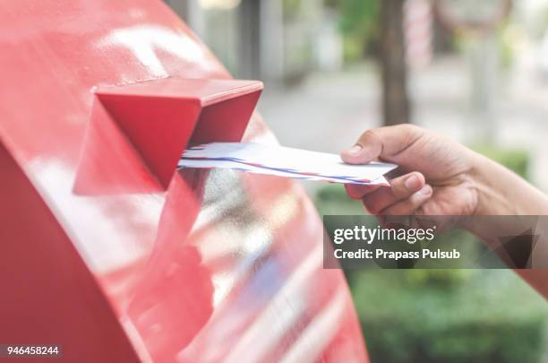 close-up of postman putting letters in mailbox - no fixed address stock pictures, royalty-free photos & images