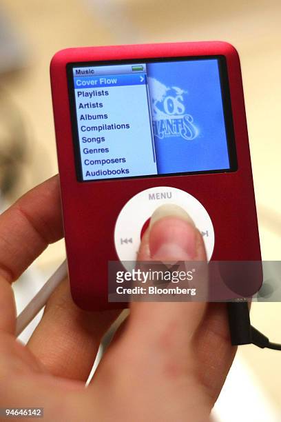 Customer holds an iPod nano inside the new Apple Store located in the Meatpacking District in New York, U.S. On Friday, Dec. 7, 2007. Die-hard Apple...