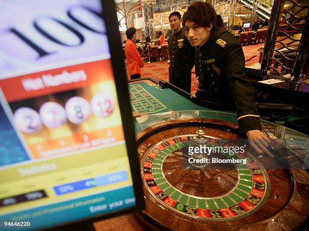 Man plays a roulette wheel at the New Grand Lisboa casino in Macau, China, on Sunday, Feb 2007. Macau gaming billionaire Stanley Ho said his company...