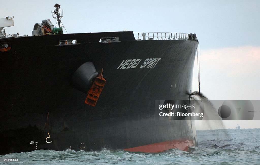 Crude oil spews out of a gash in the hull of the Hong Kong-r