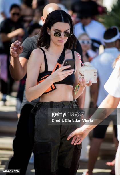 Kendall Jenner wearing cropped top, belt bag, military pants is seen at Revolve Festival on April 14, 2018 in Indio, California.