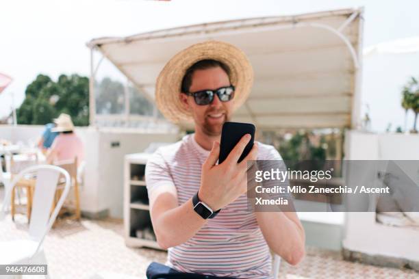 male traveler takes selfie at restaurant weather straw hat - technofobie stockfoto's en -beelden