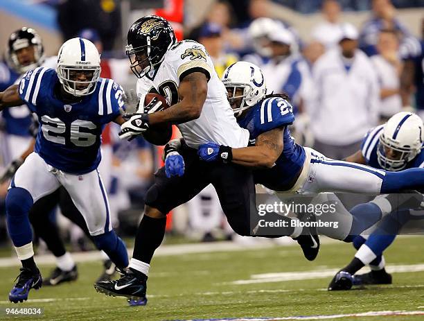 Maurice Jones-Drew, No. 32, running back for the Jacksonville Jaguars, is surrounded by Indianapolis Colts defensive players Bob Sanders, No. 21, and...