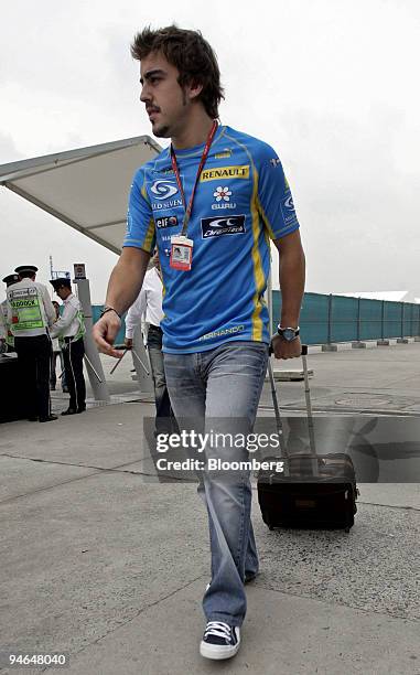 Professional racecar driver and current World Champion Fernando Alonso of Team Renault arrives for the first day of practice for the Formula 1 Grand...