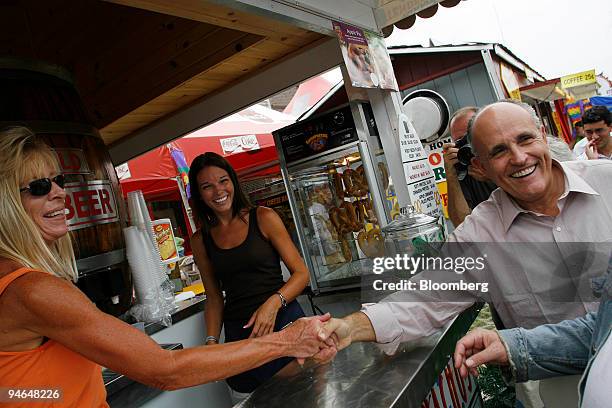 Rudy Giuliani, Republican presidential candidate and former mayor of New York, right, greets workers at a booth during a campaign stop at the Iowa...