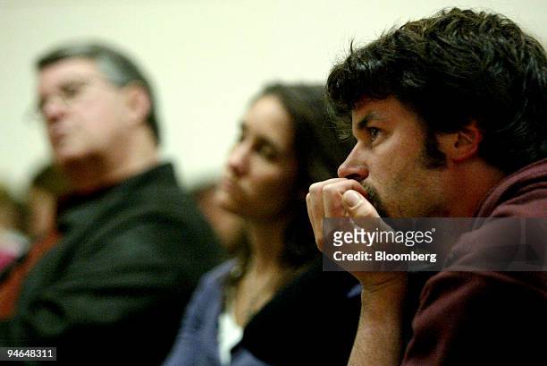 Portola resident Rich Delano, right, listens during a town meeting as a California Department of Fish and Game plan to eradicate the northern pike...