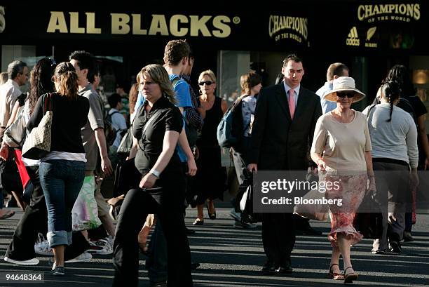 Workers cross an intersection during rush hour in Auckland, New Zealand, on Friday, Feb. 9, 2007. New Zealand wages probably accelerated at a record...