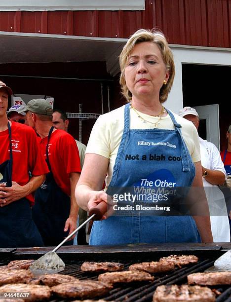 Democratic presidential candidate Hillary Clinton flips pork burgers at the Iowa Pork Producers stand while campaigning at the Iowa State Fair in Des...