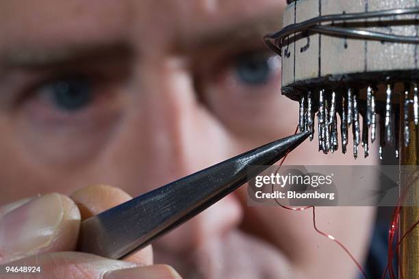 Engineer Scott Courts installs wiring onto terminals of a dilution refrigerator at Lake Shore Cryotronics in Westerville, Ohio, Friday, April 2007....