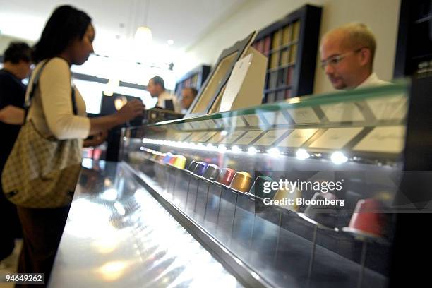 Customer buys Nespresso coffee as capsules sit on display at a Nestle Nespresso Shop in Bern, Switzerland, Wednesday, Aug. 15, 2007. The world's...