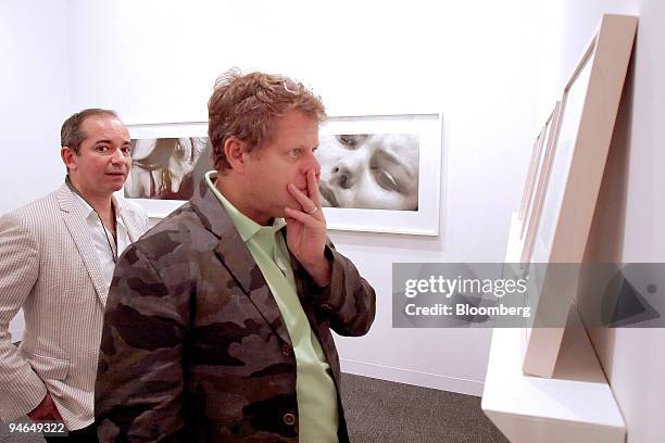 John Thornton of Austin, Texas, foreground, looks at a sumi ink on paper work by Roland Flexner during the opening of the Art Basel Miami Beach art...