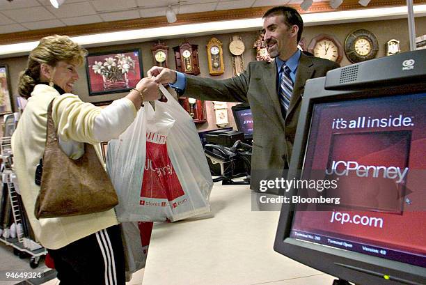 Sales Manager John O'Leary helps customer Ann Liberge with her purchases inside a JCPenney store at the Northshore Mall in Peabody, Massachusetts,...