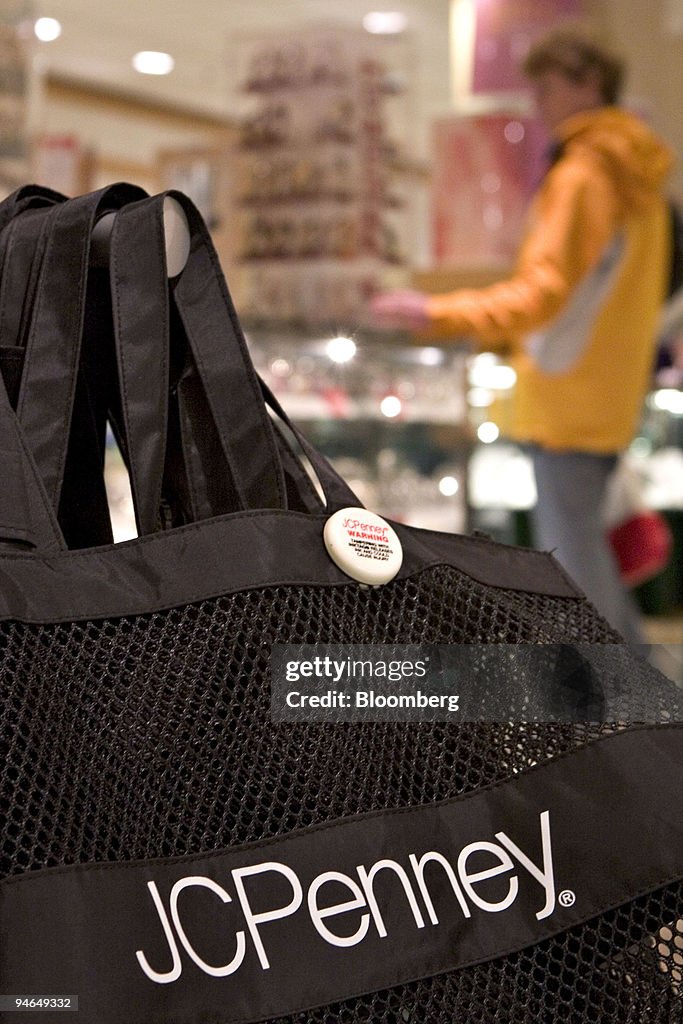 C. Penney logo is pictured on a bag as a customer shops nearby in