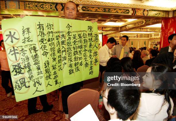 Democratic Progressive Party supporter displays a poster demanding the DPP members to unite during the party's 20th anniversary in Taipei, Taiwan,...