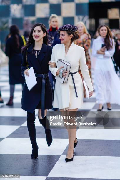 Guest wears a beret hat, a white dress, a Dior bag, black shoes ; a guest wears a blue coat, black high boots, after Dior, during Haute Couture...